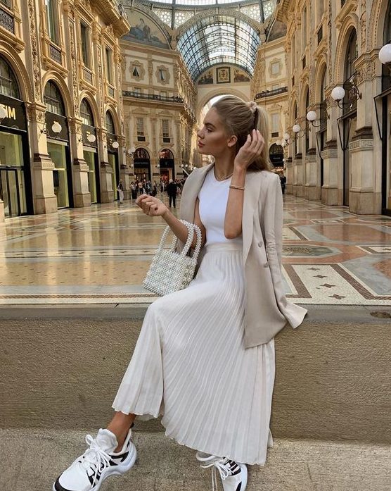 a white tee, a creamy pleated midi, a tan oversized blazer, dad sneakers and a pearly bag