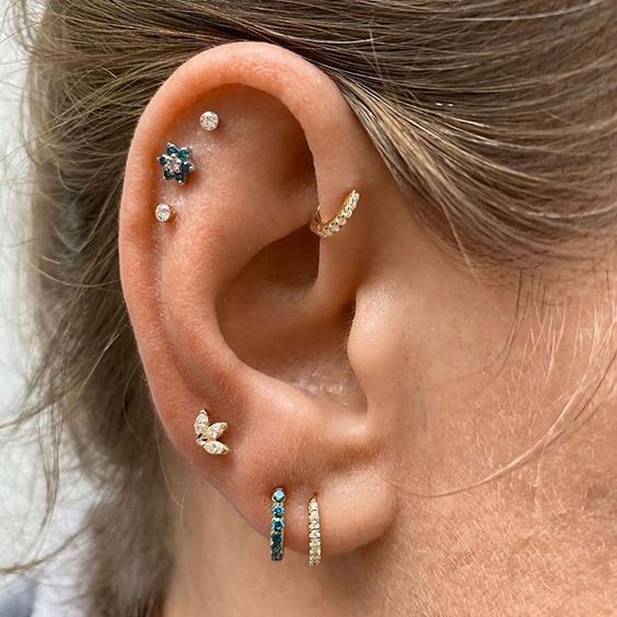 a triple lobe piercing, a triple flat piercing, a forward helix piercing done with chic rhinestone hoops and studs look amazing