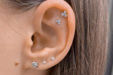 29 a triple lobe piercing and a flat plus a helix one done with beautiful diamond studs that create a stylish set