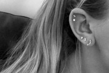 30 a triple lobe piercing plus a double flat piercing done with beautiful and matching rhinestone studs creating a set