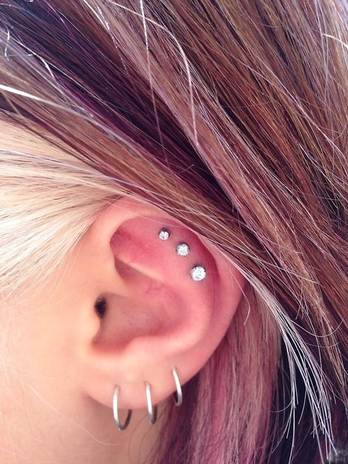 a triple love piercing plus a triple flat one, done with silver hoops and rhinestone studs that differ in size but match in look