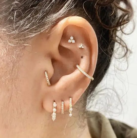 bold styling with a double flat, a conch, a triple lobe and a tragus piercing is a very cool and fresh idea to rock