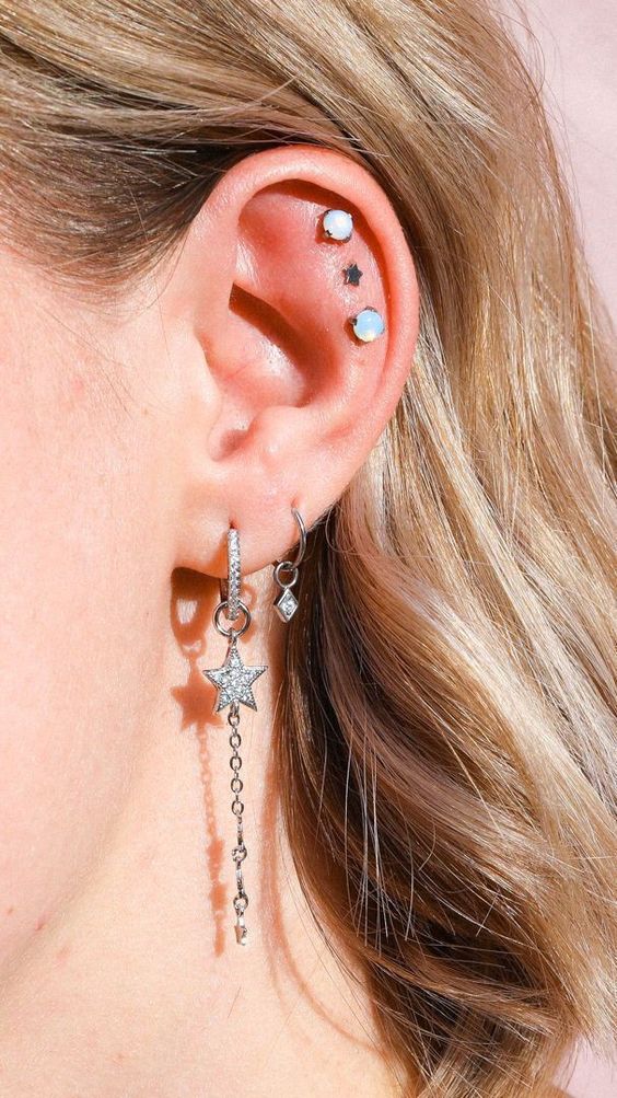 celestial ear styling with two hoops with stars, a triple flat piercing with opeal and star studs is wow