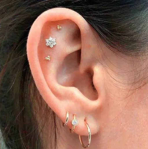 chic ear styling with a triple flat and a triple lobe piercing, with gold hoop and stud earrings is a beautiful idea