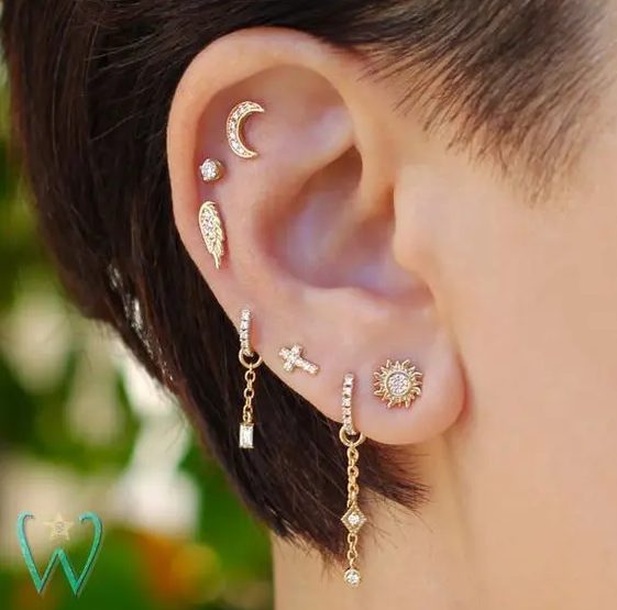 pretty earing styling with a multiple lobe piercing plus flat and helix ones done with creative chain hoops and shiny studs