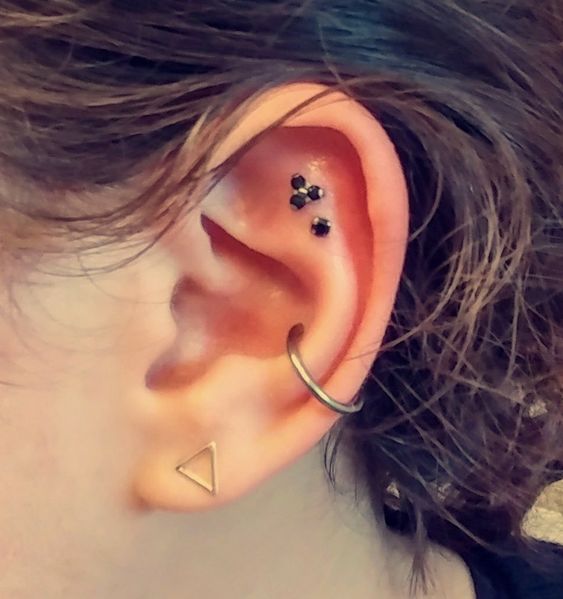 beautiful and ultra-modern ear styling with a lobe, conch and double flat piercing, with some studs and a hoop