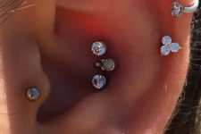 39 bold and glam ear styling with a triple conch, triple lobe, tragus, stacked helix piercings done with rhinestone studs and hoops is wow