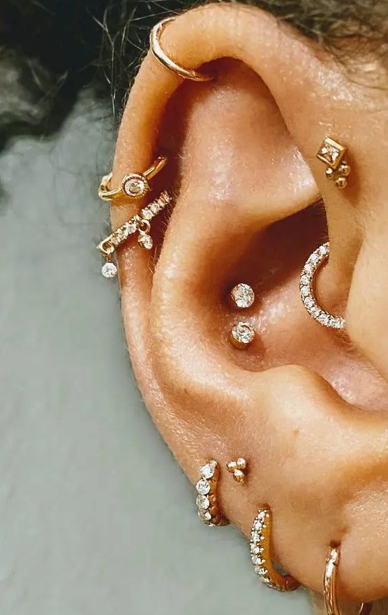 a bold and cool ear with a double conch, stacked lobe, a forward helix, stacked helix done with beautiful hoop and stud earrings