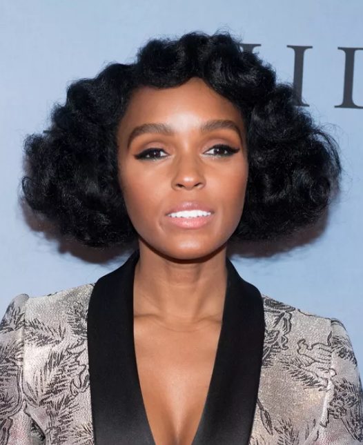 Janelle Monae's fluffy waves have a vintage pin curl effect, there are soft waves rippling over her forehead, and the round, cloud-like shape the hair takes as it moves out from her head.