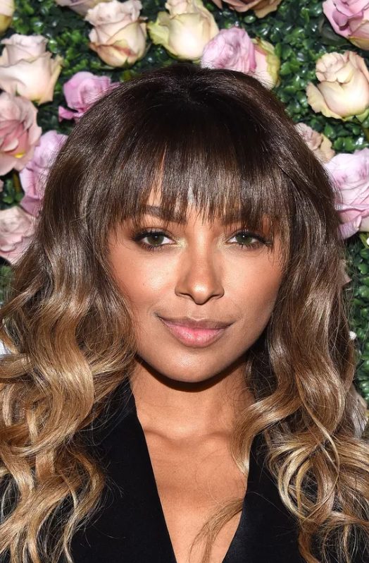 Kat Graham's cute, razored fringe with long ombré waves is a fun, modern take on the straight bangs, curly body contrast