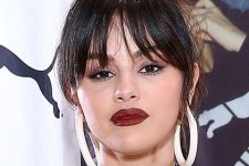 Selena Gomez wearing an updo with wispy Birkin bangs with parting in the middle looks bold, chic and dramatic
