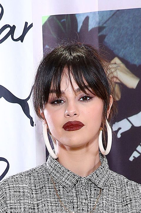 Selena Gomez wearing an updo with wispy Birkin bangs with parting in the middle looks bold, chic and dramatic
