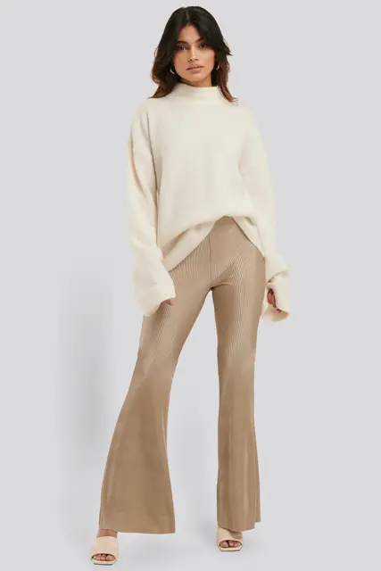 With beige oversized sweater and beige heeled mules