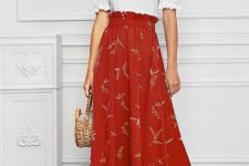 With earrings, red and beige printed high-waisted midi skirt, straw bag and golden ankle strap high heels