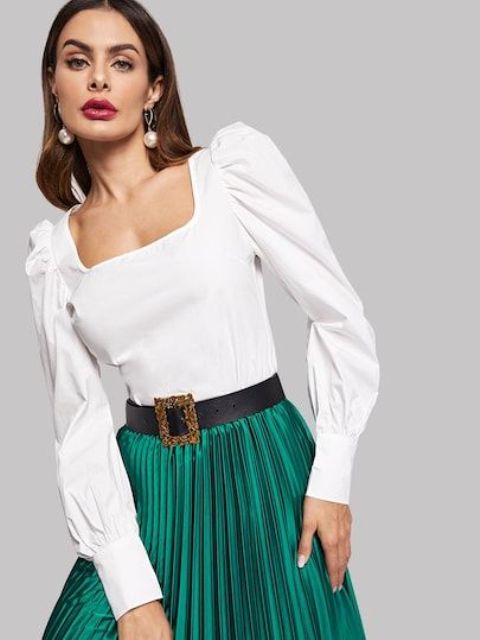 With emerald green pleated midi skirt and black embellished belt