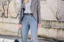 With oversized sunglasses, light gray shirt, distressed jeans, black leather belt, black pumps and black leather chain strap bag