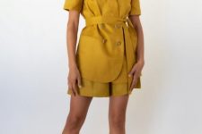 With oversized sunglasses, mustard yellow linen shorts and beige high heeled shoes