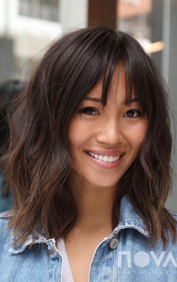 a cute layered lob with bottleneck bangs and a rich brown tone is a very chic and cool idea for a wearing now