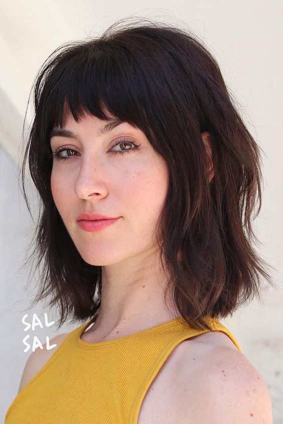 a dark brown long bob with a usual fringe and a shaggy texture is a cool and bright idea, it will make a statement