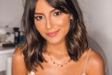 a dark brown long bob with curtain bangs and touches of softer and warmer brown is a beautiful idea, add waves for a girlish feel