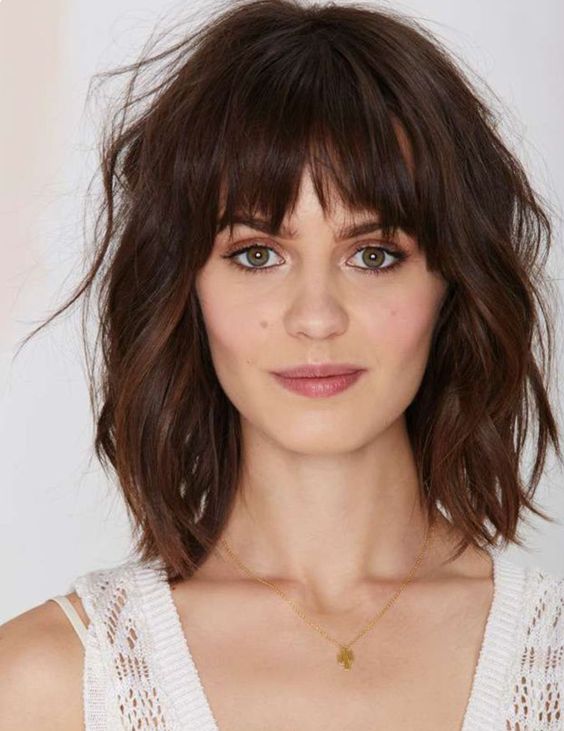 a dark brunette long bob with bottleneck bangs, waves and a lot of dimension is a super chic and cool idea
