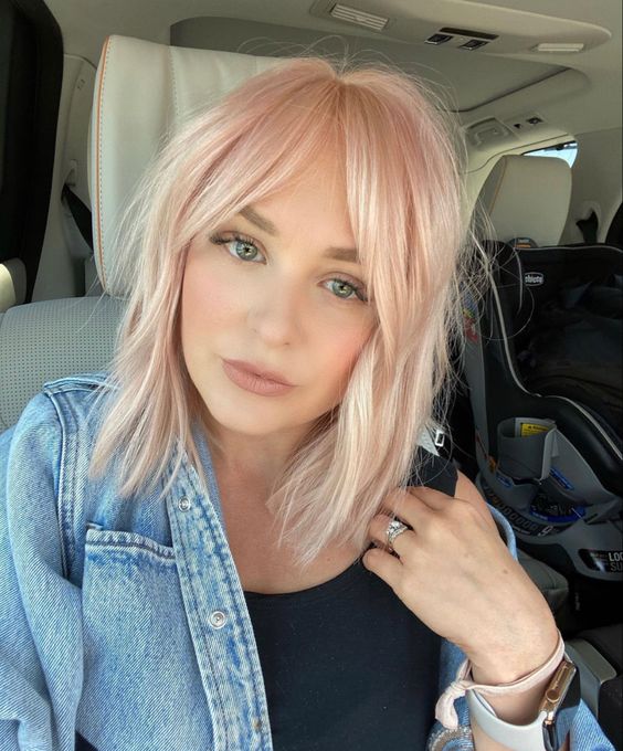 a light pink long bob with curtain bangs is a sweet and cute idea for a modern and bold look
