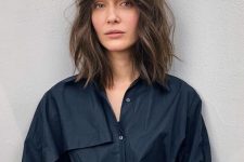 a long brown bob with slight highlights, messy waves and bottleneck bangs is a trendy solution to rock now