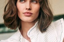 a messy brown long bob with bottleneck bangs and messy texture and volume is a chic and lovely idea