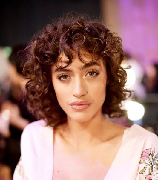 a mid-length shag is ideal for a curly texture with slightly longer bangs that graze the eyebrows