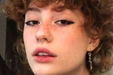 a nostril plus a septum piercing done with matching a barbell and usual hoops plus stacked ear piercings