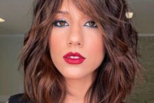 a rich brown long bob with caramel balayage and messy waves plus bottleneck bangs is a chic and catchy idea