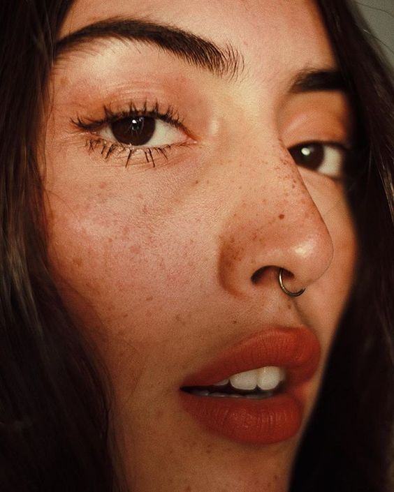 a septum piercing done with a hoop earring is a very stylish and delicate solution that doesn't stand out too much