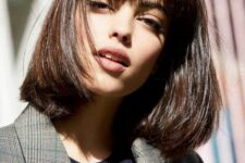 a shiny dark brown long bob with a classic fringe, with a lot of volume and curved ends is an elegant and timeless solution