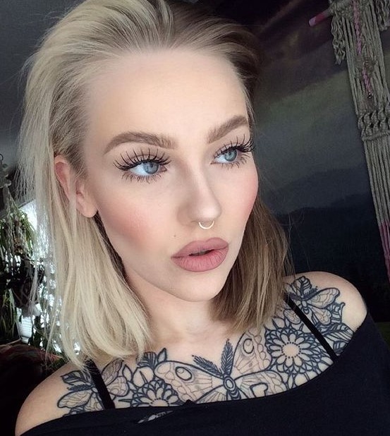 a statement tattoo and a nose hoop piercing make the girl's look super bold and outstanding