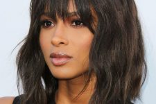 a stylish black and brown messy wave bob with overgrown bangs that add a messy and effortlessly chic touch