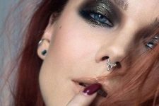 a super bold makeup with black and gold glitter smokeys and a septum piercing with a delicate and catchy hoop