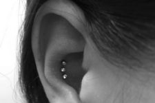 a triple conch piercing done with rhinestone studs is a stylish and out-of-the-box idea to stand out for sure