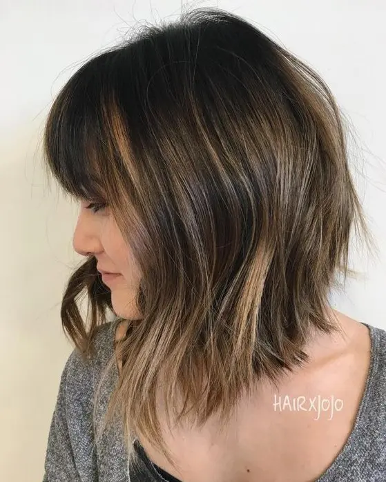 an inverted long brunette bob with caramel highlights and waves plus a fringe is a chic and stylish idea to try