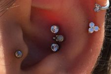bold and glam ear styling with a triple conch, triple lobe, tragus, stacked helix piercings done with rhinestone studs and hoops is wow