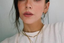 bold piercings – a septum, a nostril and multiple helix ones all done with matching gold hoops for a super bold look