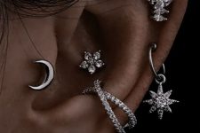 chic and bold ear styling with stacked lobe, a tragus, stacked helix and a double conch piercing done with hoops and studs