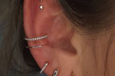glam ear styling with stacked lobe piercings with hoops, a double conch piercing with hoops and a double flat piercing with studs