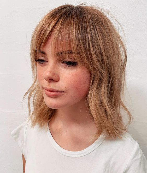 light copper hair with messy waves and bottleneck bangs is a lovely relaxed idea that shows off both color and texture