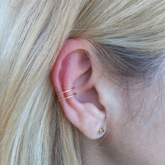 minimalist ear styling with a single lobe piercing and a double conch piercing with gold hoops and a gold stud earring
