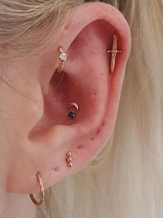 pretty and creative ear styling with stacked lobe piercings with hoops and studs a double conch piercing with studs a forward helix and a helix piercing