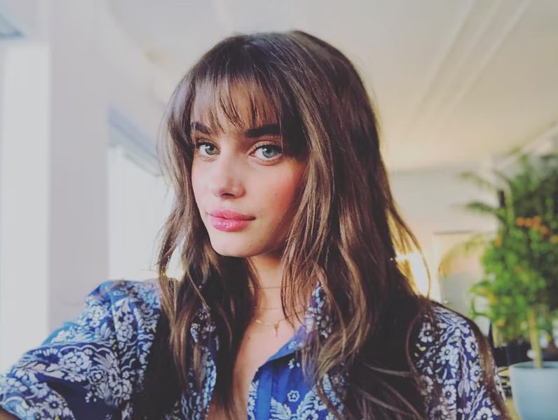 Model Taylor Hill styled her messy bangs with flushed cheeks and a berry stained lip