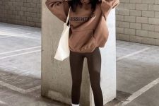 18 dark brown leggings, a brown hoodie, black sneakers and white socks, a white tote for a comfy spring look