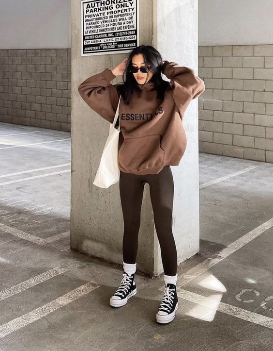 dark brown leggings, a brown hoodie, black sneakers and white socks, a white tote for a comfy spring look