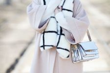 With black and white checked trousers, pale pink knee-length coat, black and white checked faux fur scarf and oversized sungalasses