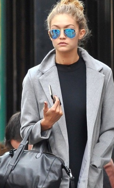 With black shirt, light gray coat, black leather bag and jeans